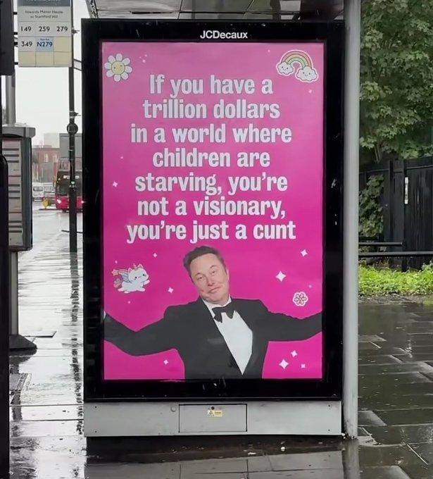 Billboard on the side of a bus stop in London shows a picture of Space Karen in a tuxedo with the text

IF YOU HAVE A TRILLION DOLLARS IN A WORLD WHERE CHILDREN ARE STARVING, YOU'RE NOT A VISIONARY, YOU'RE JUST A CUNT